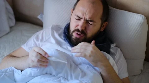 The man is sick in bed, checking the temperature. Stock Footage 145915913