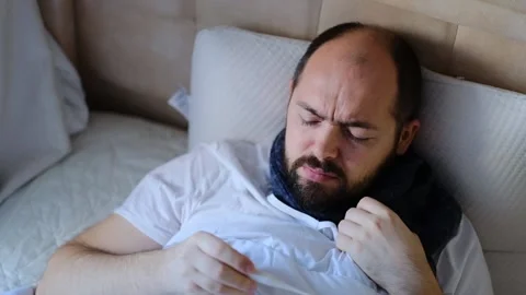 The man is sick in bed, checking the temperature. Stock Footage 145915954