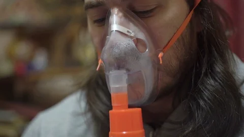 Man is sick, does medical procedures, therapeutic inhalation, watches in Stock Footage 122136959