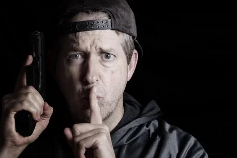 Man signaling to be quit while holding weapon Stock-Fotos