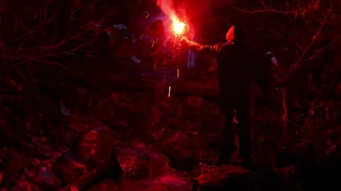 Man Signals For Help With Flare Near Waterfall Stock Footage