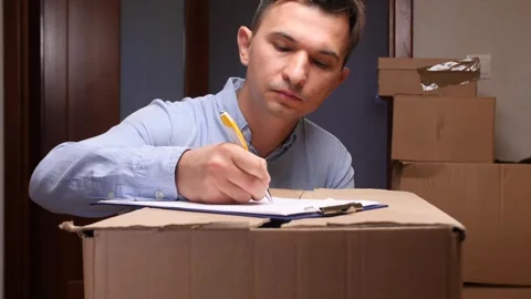 Man signing delivery document for received package 스톡 동영상 318982366