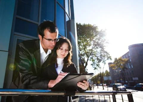 Man signing papers while standing on street Stock Photos