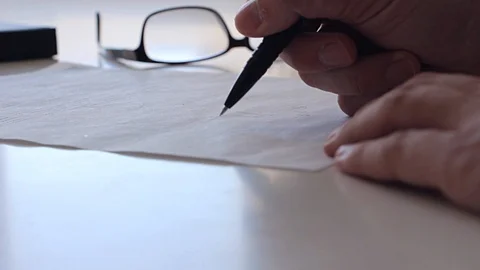 Man signs document Stock Footage 89094380