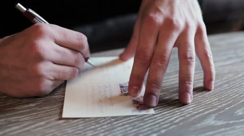 Man signs a postcard Stock Footage 47557814