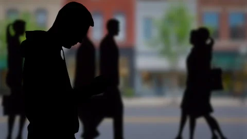 Man in silhouette looking at smartphone downtown Stock Footage 346329704