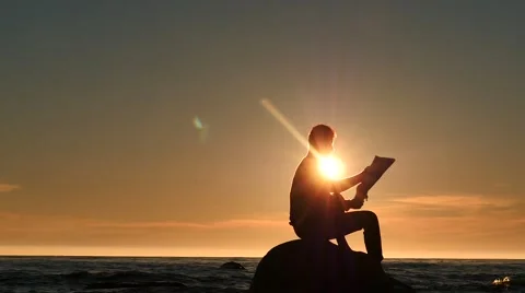 Man silhouette read a newspaper in a small island in the sea Stock Footage 64463023