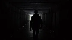 silhouette man walking tunnel
