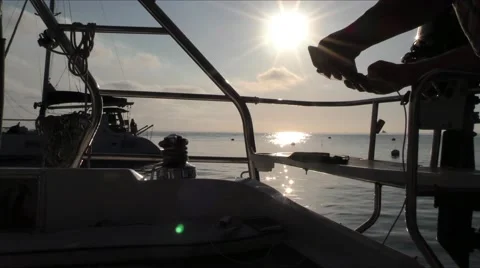 Man in silhoute checking his phone at the stern of a sailing yacht while sun Stock Footage 67521107