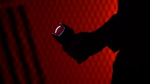MAN IN SILOHUETTE PULLS A STUN GUN AND TRIGGERS IT.  IN 4K, 10 BIT, 4:2:2. Stock Footage 99704064