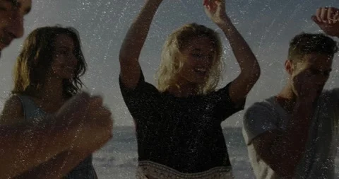 Man singing, crew dancing beach, song sparking waves, phone likes, raising cup Stock Footage 330509134