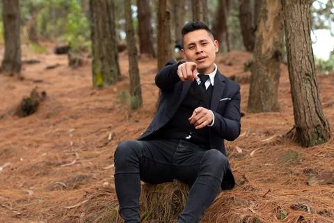 Man singing in the forest pointing at the camera with attractive look. Foto stock