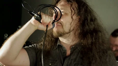 Man singing song into microphone, having performance with rock band in studio 4K Stock Footage 113004264