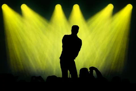 Man singing on stage under spots Stock Illustration