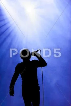 Man singing under floodlight at open-air concert Stock Illustration