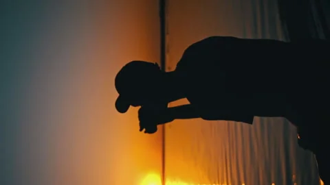 Man Sipping Drink While Wading In Water At Sunset Video stock 275474196