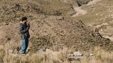 Man Sipping Mate on Rugged Mountain Cliff Stock Footage 336035878