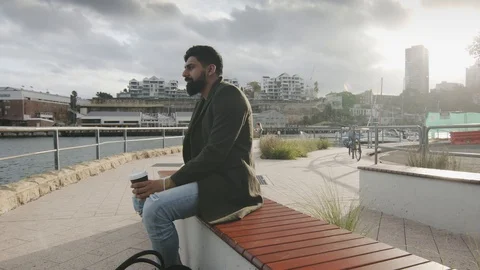 Man Sips Coffee Looking at Bay Water In Sydney Harbor. Wide Shot Dolly Stock Footage 129486071