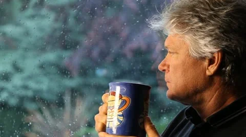 MAN SIPS COFFEE AT A RAINY WINDOW Stock-Footage 10887682
