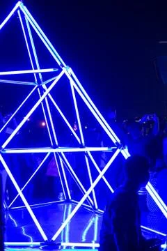 Man sit with abstract violet triangle neon light background in concert party Stock Photos
