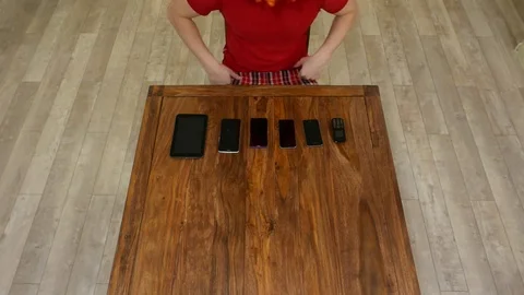 Man sit against mobile devices, difficult to choose, try some and pick up simple Vídeos de archivo 71602851