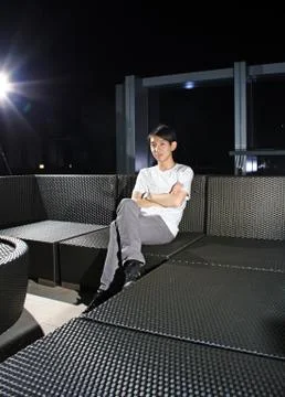 Man sit on a bench while relaxing at a pub. Stock Photos