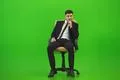 The man sit of the chair on the green background Photo