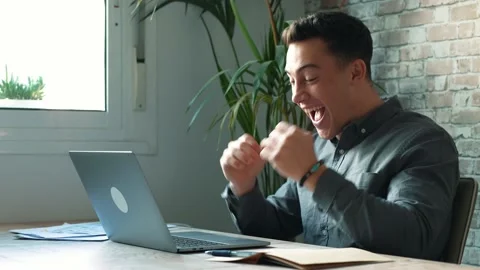 Man sit at desk read e-mail on laptop makes yes gesture feels happy. Male e.. Stock Footage 236929987