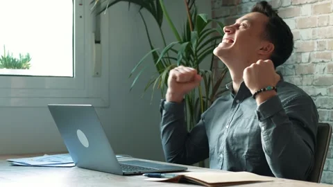Man sit at desk read e-mail on laptop makes yes gesture feels happy. Male e.. Stock Footage 236934831