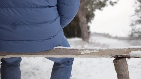 The man sit down on a snowy bench Stock Footage 72237512