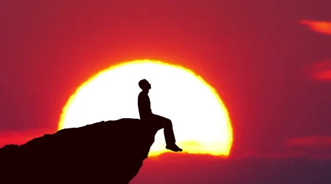 Man sit on the edge of a cliff on the background of sunrise. Real time capture Stock Footage 61101093