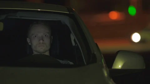 The man sit inside the car on the road. Evening night time Stock Footage 74562085