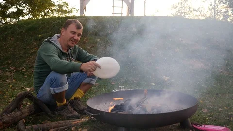 Man sit making campfire enjoy spend camping evening time outdoors on nature Video stock 117683674