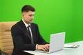 The man sit near the laptop on the green background Photo