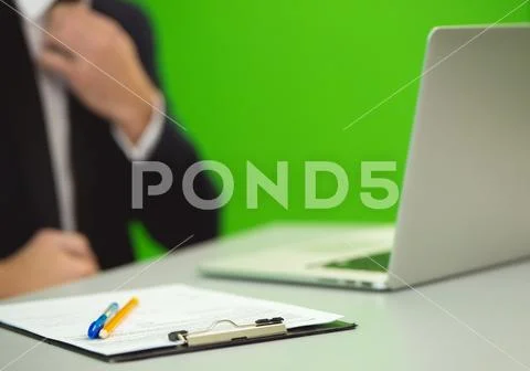 The man sit near the laptop on the green background Stock Photos