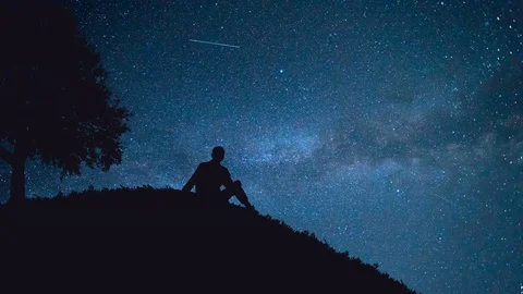 The man sit near a tree on the background of the starry sky. time lapse Stock Footage 77002127