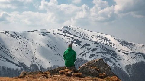Man sit on rock in spring mountains Video stock 107331271