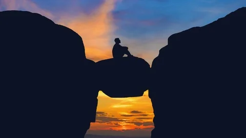 The man sit on the stone on the background of sunrise. Time lapse Stock Footage 72375368
