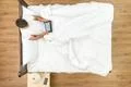The man sit with a tablet on the bed. View from above Photo