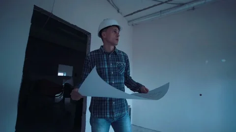 Man on a site with blueprint Stock Footage 74487693