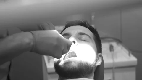 Man siting in dentist chair, pull up a tooth Stock Footage 81179834