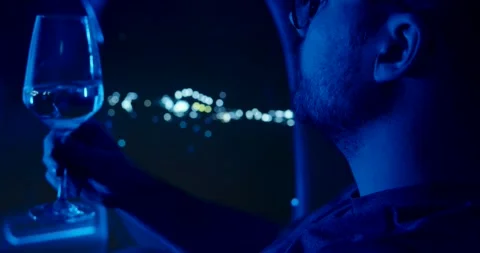 A man sits in an airplane and drinks wine, night flight Stock Footage 299905305