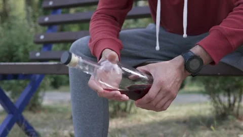 A man sits alone with a bottle, torn between drinking and staying sober. Stock Footage 315551987