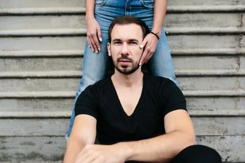Man sits on a background gray wall Stock Photos