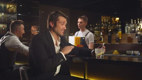 Man sits at the bar and talks by video link on the phone Stock Footage 123674538