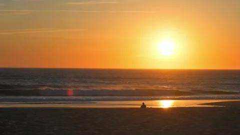 Man sits on the beach and Contemplating of the sea waves during sunset. Hum.. 스톡 동영상 249625296