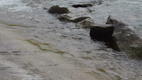 A man sits on the beach. He is in a jacket, it's cold outside Stock-Footage 96115686