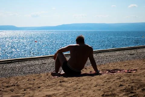 Man sits on a beach Foto stock