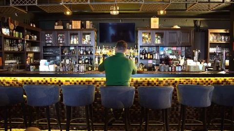 A man sits behind a bar and takes a selfie Stock Footage 126029416