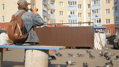 A man sits on a bench and drinks beer. Slow motion 10.19.2019 Ukraine, Kiev Stock Footage 127688113